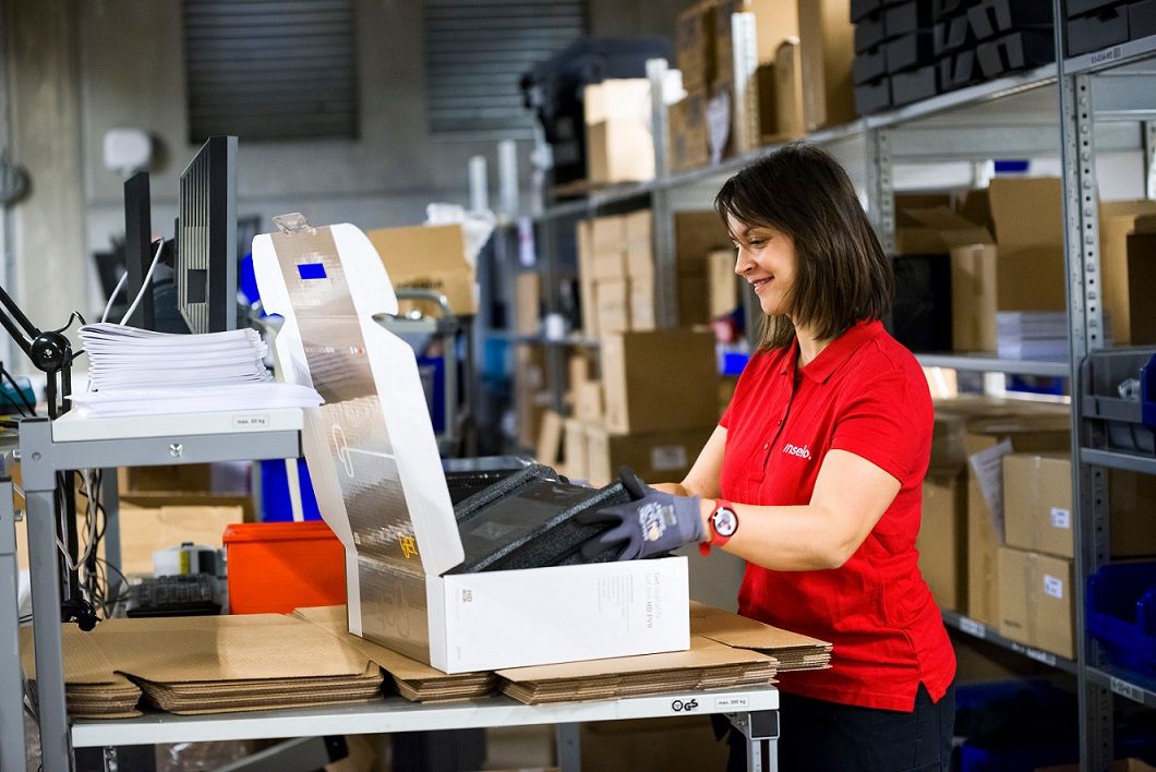 En logistikk helt pakker en pakke for distribusjon til en kunde 